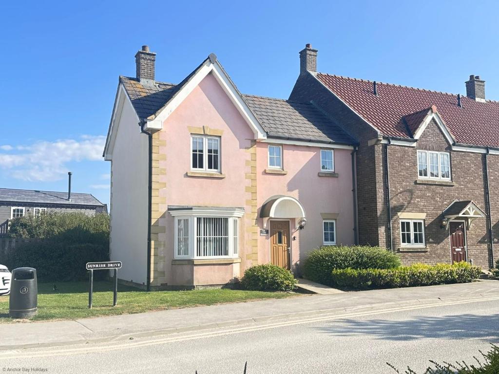 a pink house on the side of a street at Paddys Corner in Filey