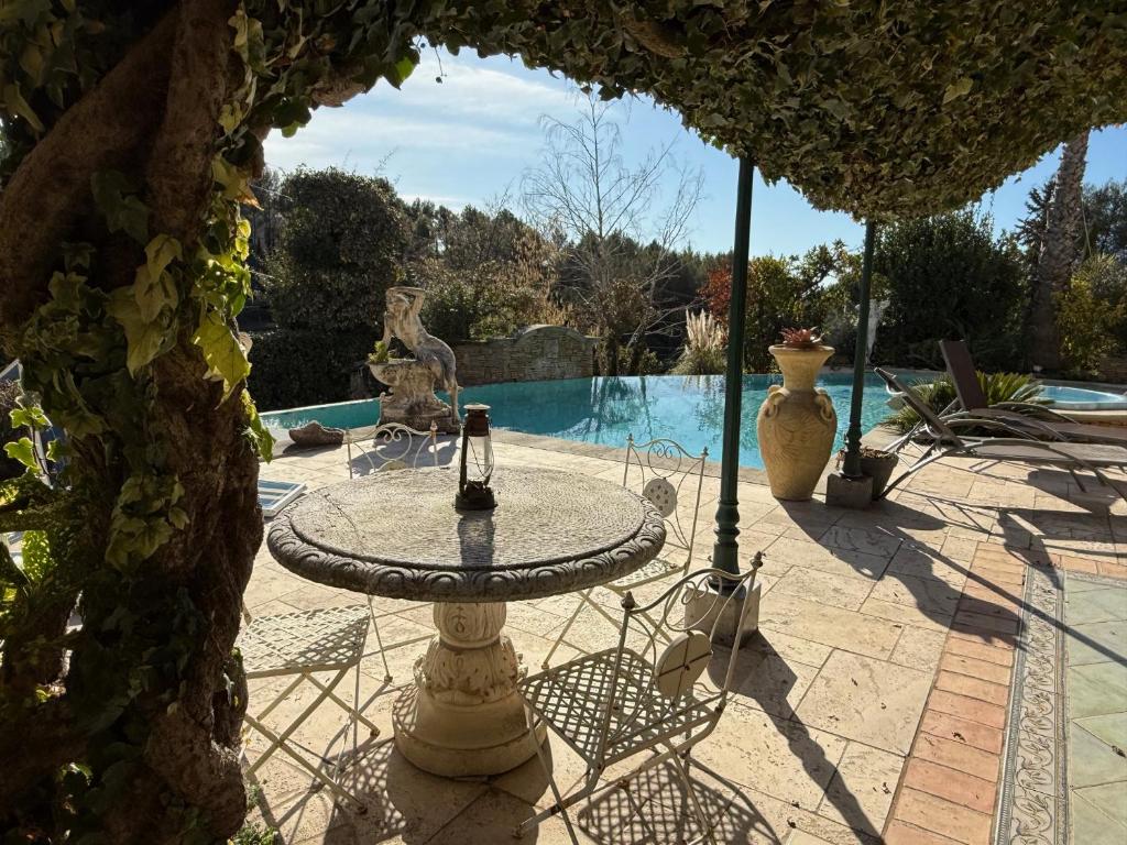 un patio avec une table et des chaises et une piscine dans l'établissement New Auriol Apartment, à Auriol