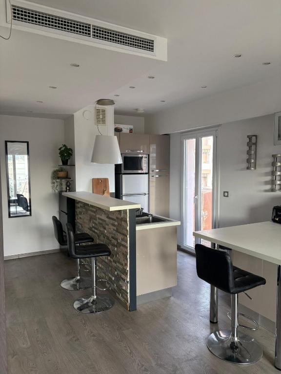 une cuisine avec un comptoir et des tabourets dans une pièce dans l'établissement Beau studio climatisé très proche de la mer, à Cagnes-sur-Mer