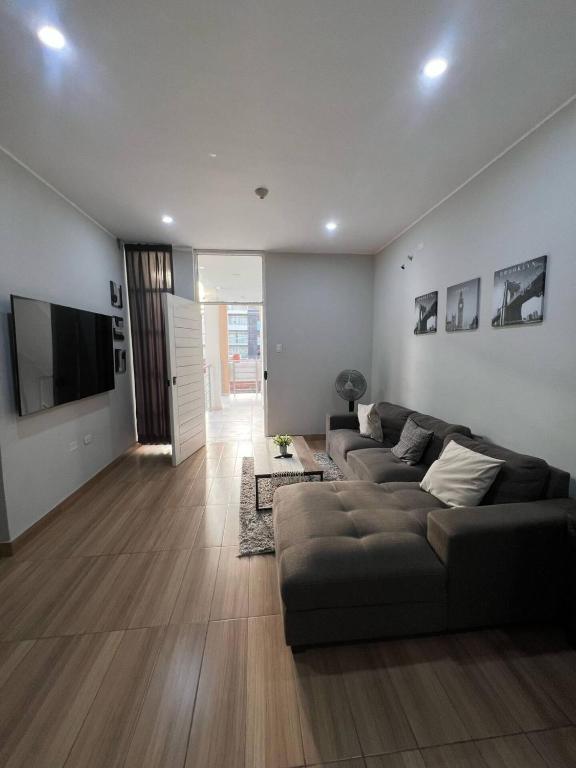 a living room with a couch and a flat screen tv at Apartamento Miraflores country club in Piura