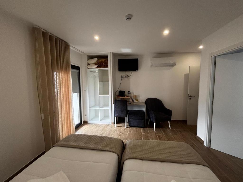 ein Schlafzimmer mit einem Bett und einem Schreibtisch in einem Zimmer in der Unterkunft Solar de São Pedro in Monção