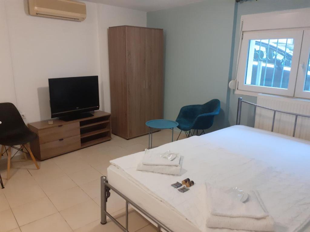 a living room with a table and a tv at Blue Studio in Kavala