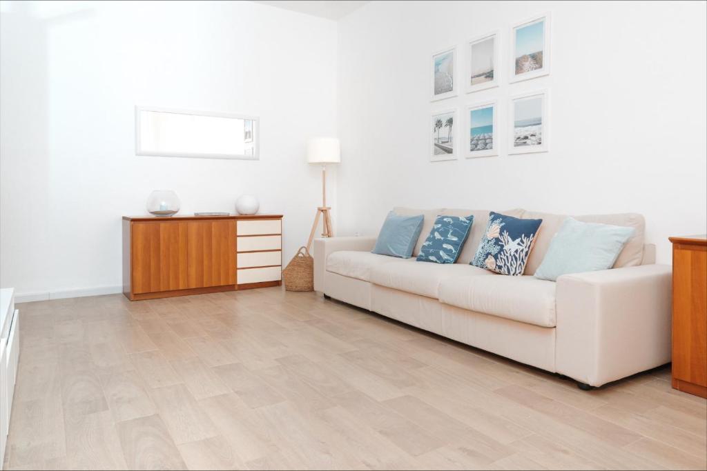 een woonkamer met een witte bank en een tafel bij La Maison Calasetta in Calasetta