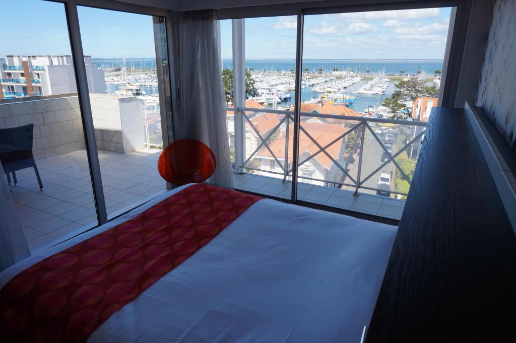 a bedroom with a bed and a view of a harbor at Hôtel Le Nautic in Arcachon