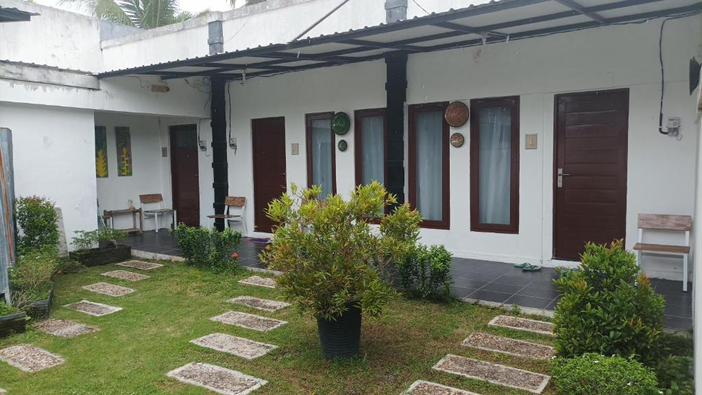 a house with a courtyard with trees and plants at Beruk Angis Guest House & Kost in Palangkaraya