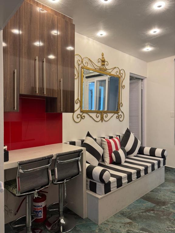 a living room with a couch and a mirror at Emerald Suite Summerstrand in Gqeberha