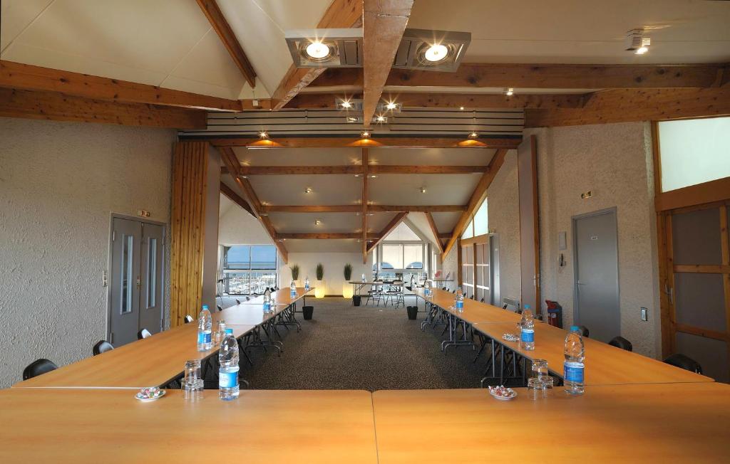 a large conference room with long tables and chairs at Hôtel Le Nautic in Arcachon