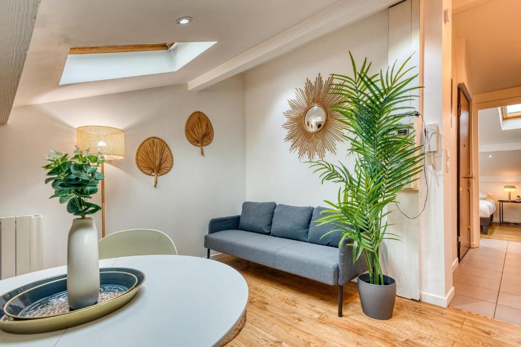 un salon avec un canapé bleu et des plantes dans l'établissement Le Petit Tolstoï - Appart cosy 2pers, à Villeurbanne