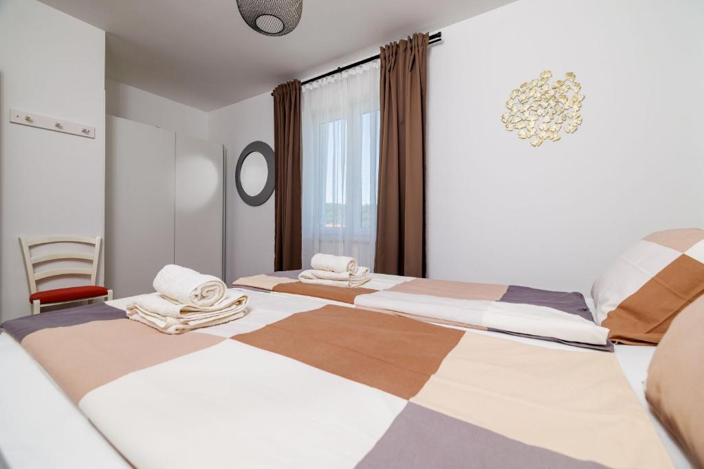 a bedroom with two beds with towels on them at Apartment Iva in Šilo