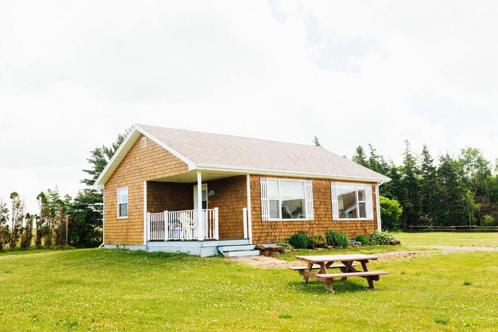 a small house with a picnic table in front of it at Greenwich View Cottages (Unit #3) in Saint Peters