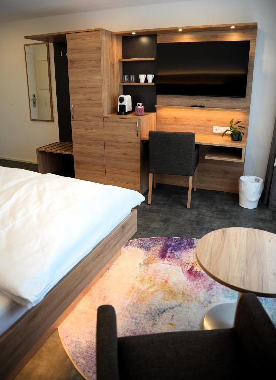 a hotel room with a bed and a desk at 7Rooms in Reutlingen