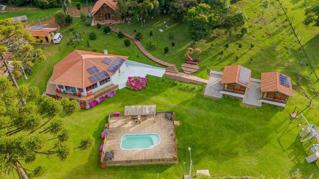 an aerial view of a house with a pool on a lawn at Chácara Santa Rita - Campo Magro | Gonzaga Stays in Campo Magro