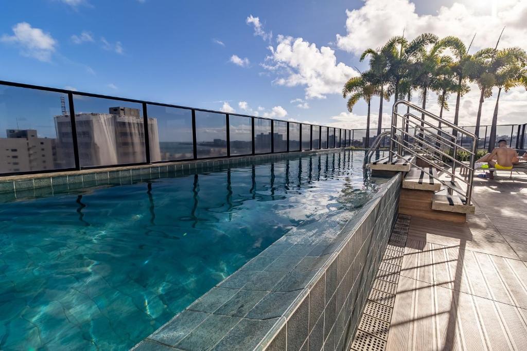 a swimming pool on top of a building with palm trees at STUDIO/ESTÚDIO TOP - Praia 200M & Lazer Incrível / Stylish Stúdio - 200M Beach & Great Amenites in Maceió