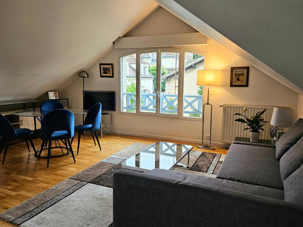 un salon avec un canapé et une table dans l'établissement Esprit Loft Rueil centre, à Rueil-Malmaison