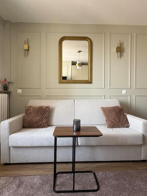- un salon avec un canapé blanc et un miroir dans l'établissement Studio Prestige Paris Porte de Versailles, à Vanves