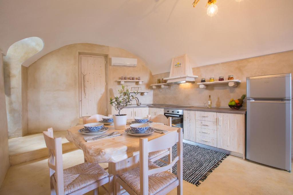 a kitchen with a wooden table and a refrigerator at Love Nest with hot tub, hammam & outdoor cinema in Akrotiri