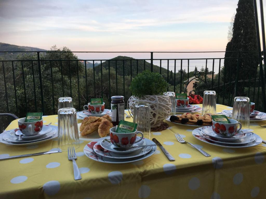 a table with a yellow table cloth with food on it at Villa Angelo in Paleokastritsa
