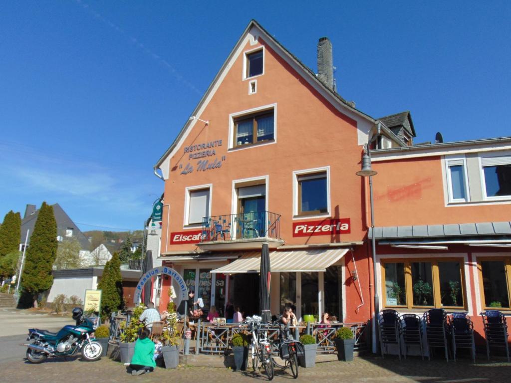 Ein Gebäude mit Leuten, die draußen sitzen. in der Unterkunft Gästehaus La Mula in Treis-Karden