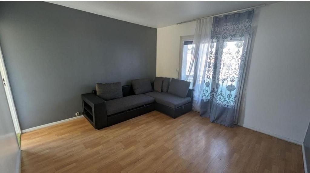 un salon avec un canapé et une fenêtre dans l'établissement Damene, à Perpignan