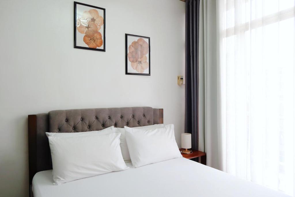 a bedroom with a bed with white pillows and a window at Burnham Place Leisure Stay Unit 1 in Baguio