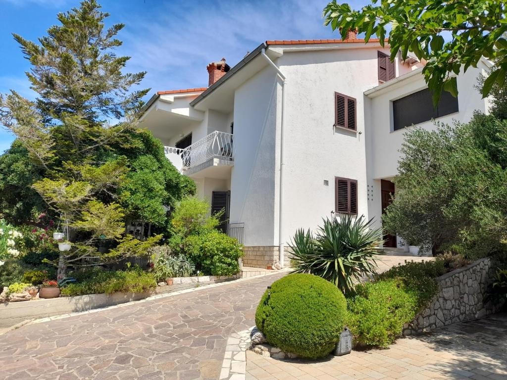 a large white house with a driveway at Apartments with parking space Banjol, Rab - 16334 in Rab