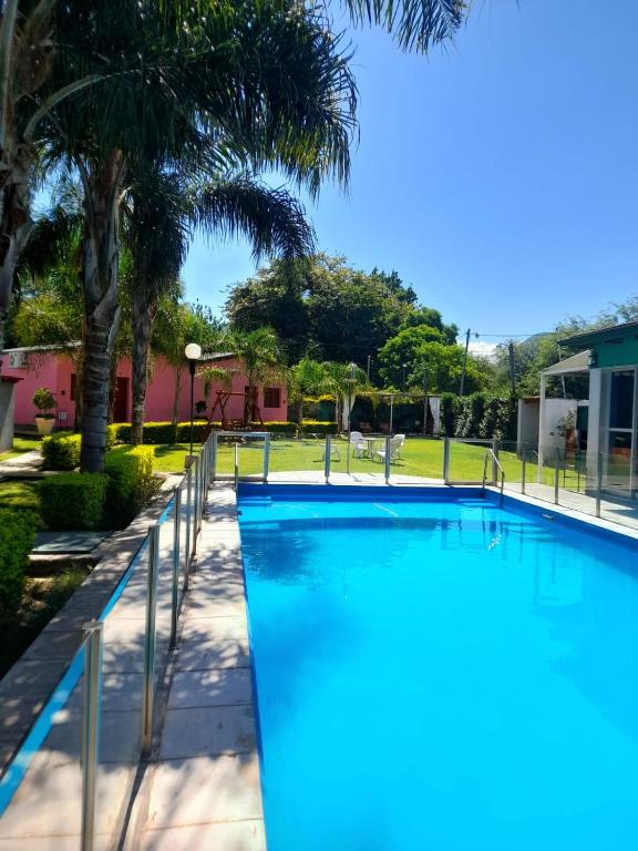 a swimming pool in a resort with palm trees at Cabañas Puertas del Sol in La Rioja
