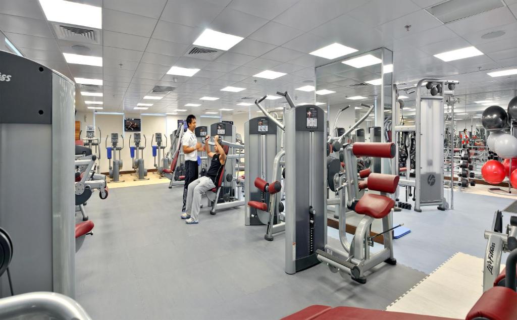 a gym with lots of equipment and people in it at City Premiere Hotel Apartments - Dubai in Dubai