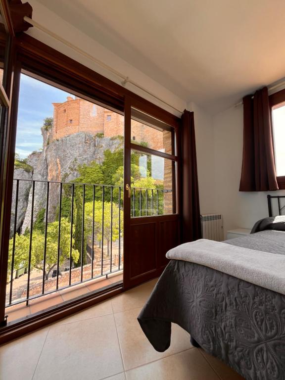 una camera da letto con un letto e un balcone con vista di Apartamento Pasarelas Ventanal ad Alquézar