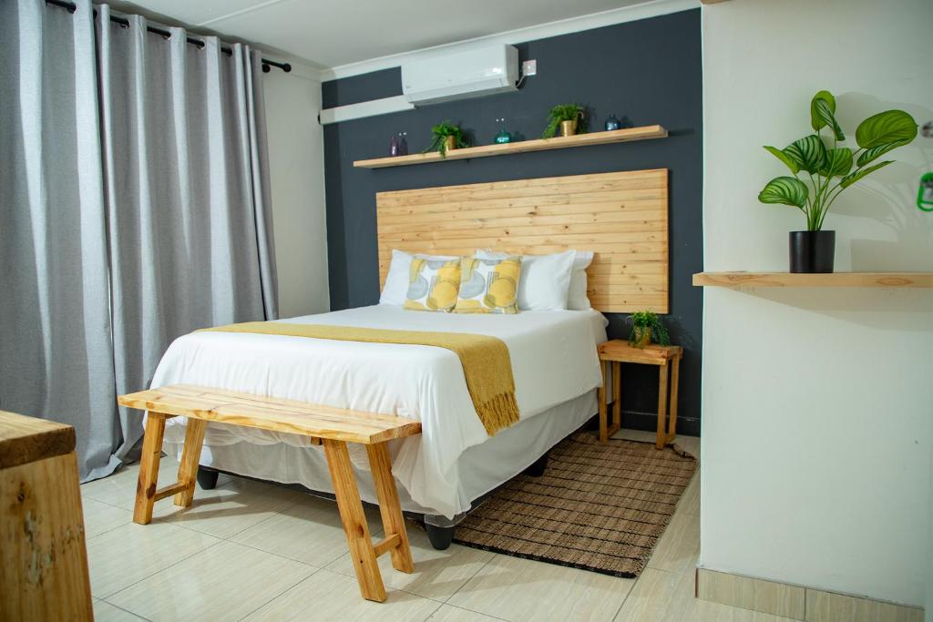 a bedroom with a bed with a wooden headboard at Kanana Villas - Maun 2 bedroom apartment in Maun