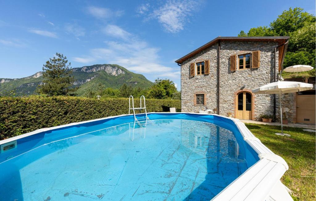 uma grande piscina em frente a uma casa de pedra em Nice Apartment In Borgo A Mozzano em Borgo a Mozzano