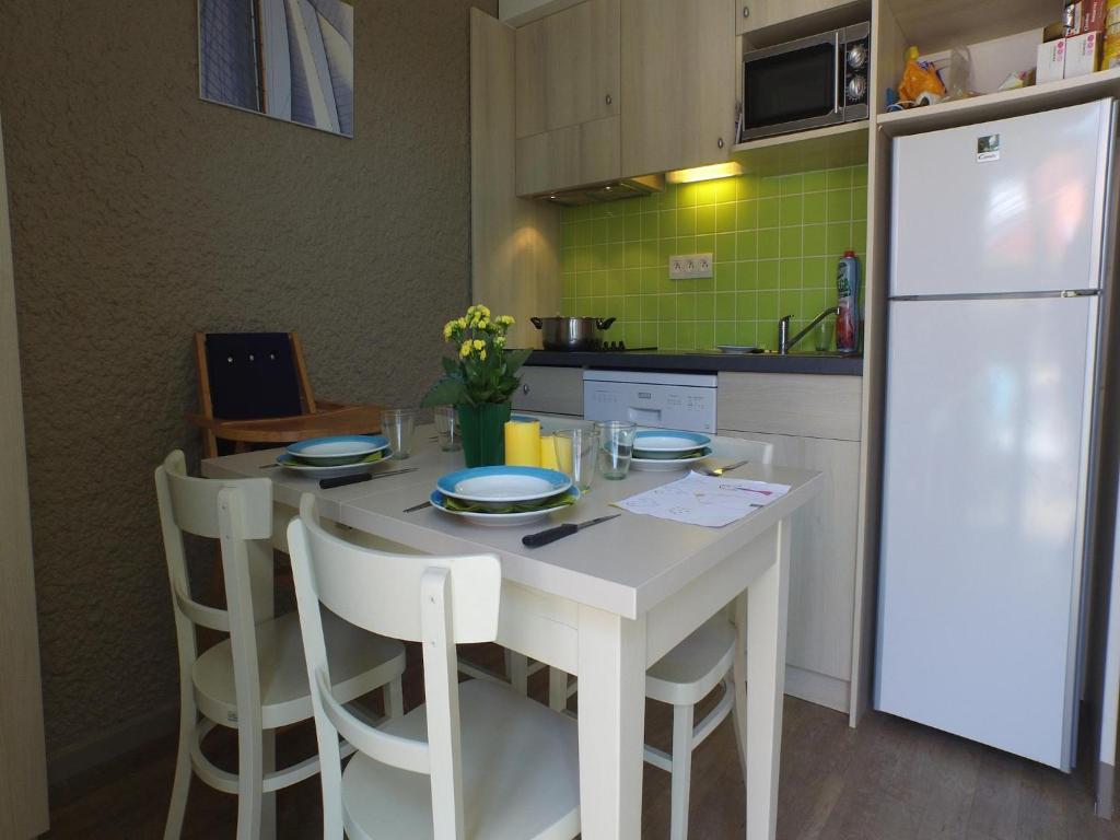 Il comprend une cuisine équipée d'une table blanche et d'un réfrigérateur blanc. dans l'établissement Apartment in Port-Bail near Sandy Beach, à Port-Bail-sur-Mer