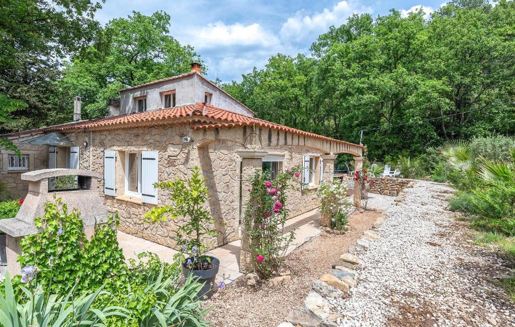 a small stone house with flowers in a garden at Amazing Home In Le Val in Le Val