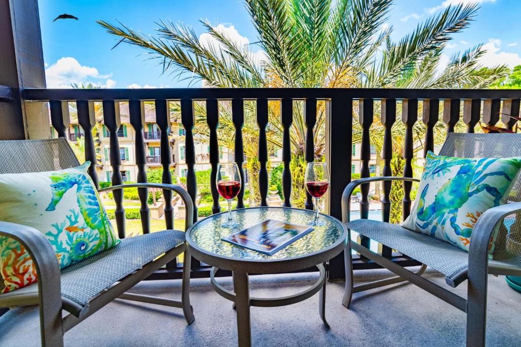un patio con 2 sillas y una mesa con copas de vino en 5322-1P Top Floor 1 BR overlooks pool courtyard -, en St. Augustine