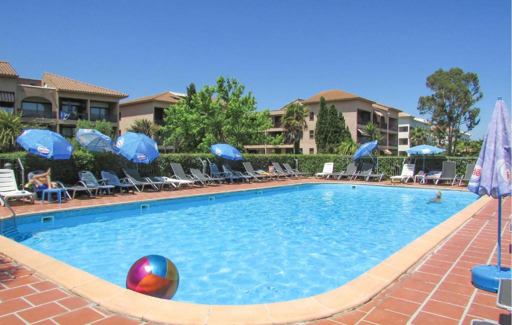 - une piscine avec un ballon, des chaises et des parasols dans l'établissement Gorgeous Apartment In Moriani, à Moriani-Plage
