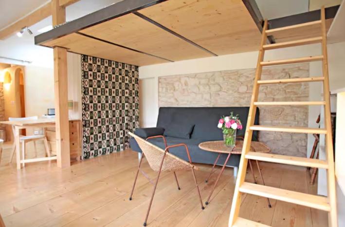 - un salon avec une mezzanine et une table dans l'établissement Bungalow Champigny sur Marne, France, à Champigny-sur-Marne