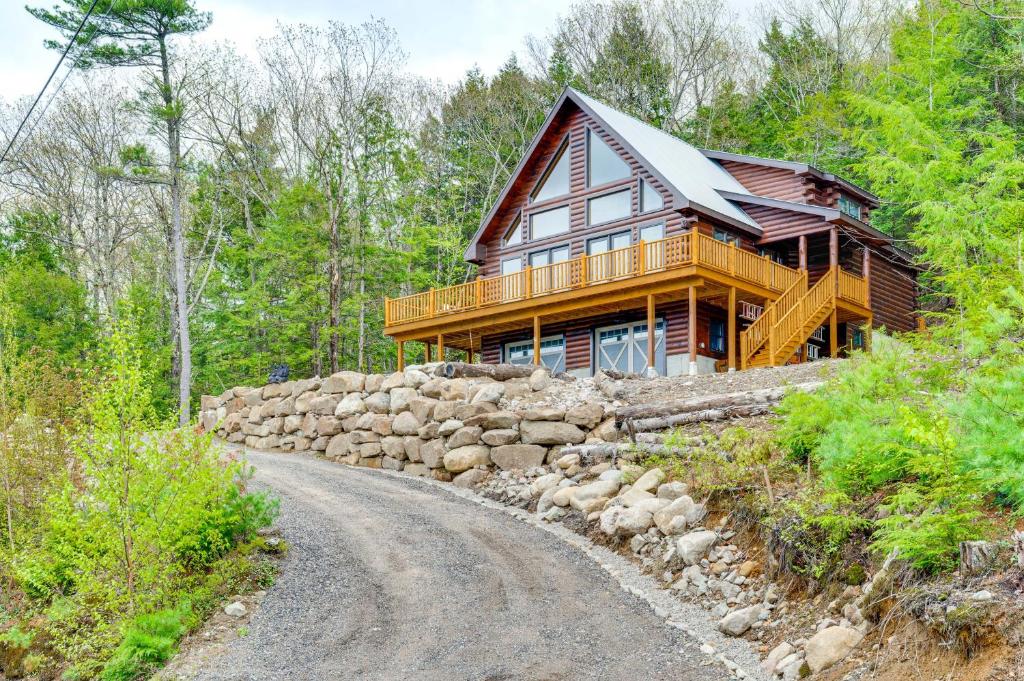 a wooden house on a hill with a gravel road at Mtn-View Deck Scenic Conway Log Cabin! in Conway