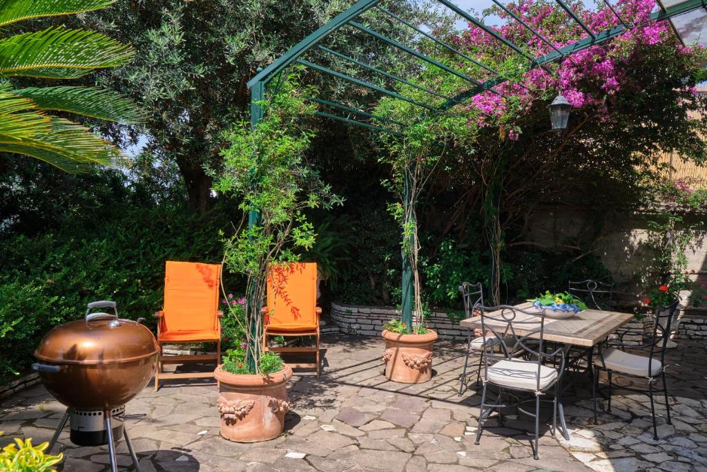 a patio with a table and chairs and plants at Villa Santa Sofia in Vico Equense