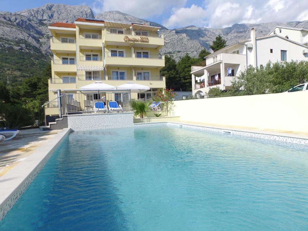 a swimming pool in front of a hotel at Dorijini Dvori in Baška Voda