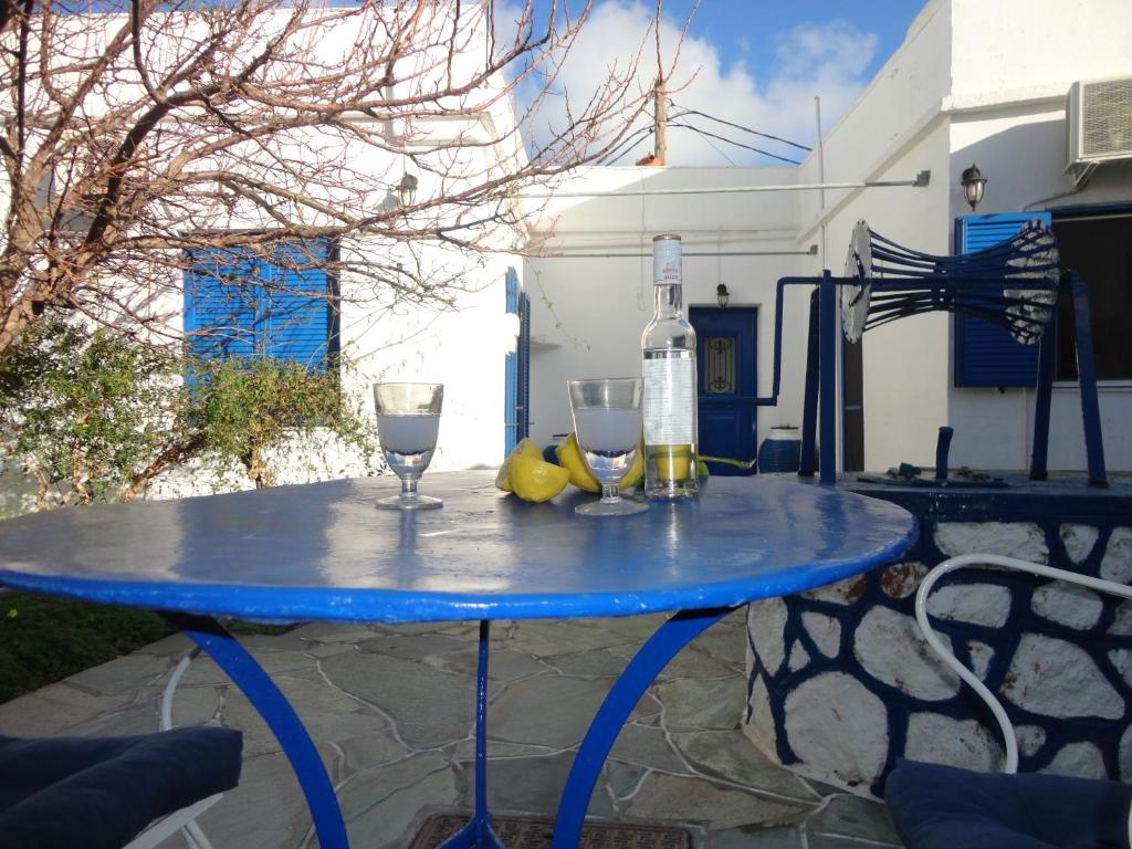 a blue table with two wine glasses and a bottle at Alexandros House in Apollonia