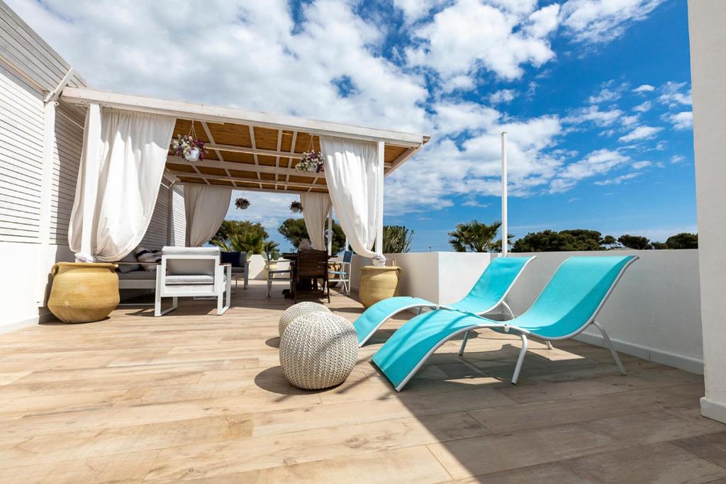 サンタ・マリア・デル・フォカッロにあるRomantic House terrazza vista mareの青い椅子とフェンス付きのパティオ