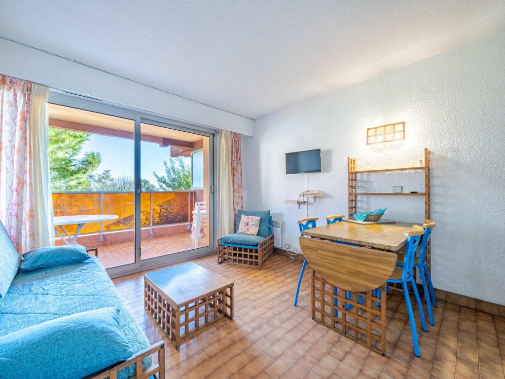 un salon avec un canapé bleu et une table dans l'établissement Appartement 8 pers, spacieux, vue mer, Wi-Fi inclus - FR-1-827-8, à Roquebrune-Cap-Martin