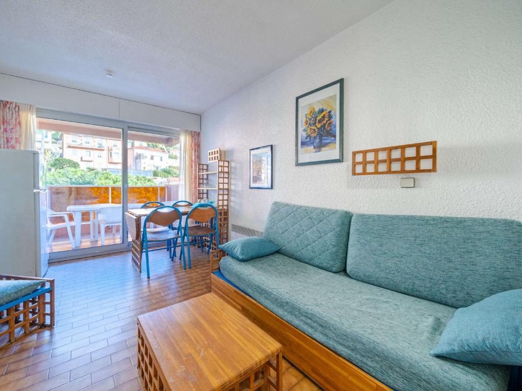 un salon avec un canapé bleu et une table dans l'établissement Appartement pour 8 avec Wi-Fi et vue sur mer - FR-1-827-24, à Roquebrune-Cap-Martin