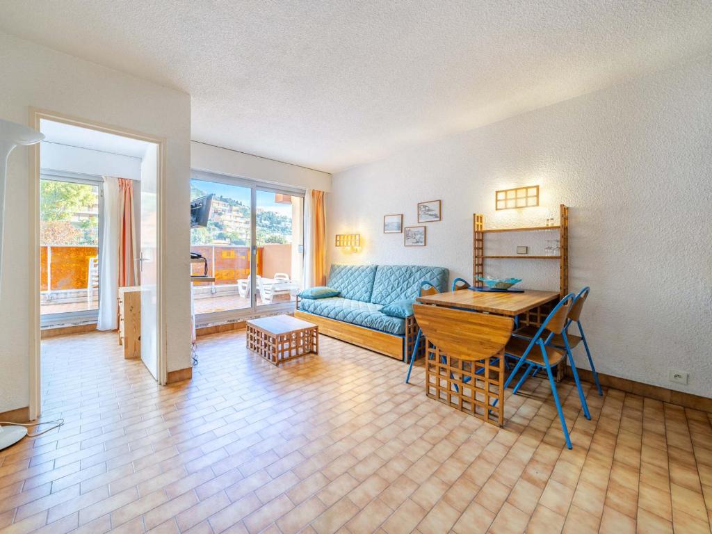 un salon avec un canapé bleu et une table dans l'établissement Appartement 8 pers, séjour spacieux, vue mer & Wi-Fi - FR-1-827-4, à Roquebrune-Cap-Martin