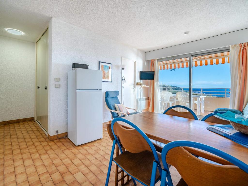 d'une salle à manger avec une table, des chaises et un réfrigérateur. dans l'établissement Appartement pour 8 personnes avec vue mer, Wi-Fi inclus à Roquebrune-Cap-Martin - FR-1-827-16, à Roquebrune-Cap-Martin