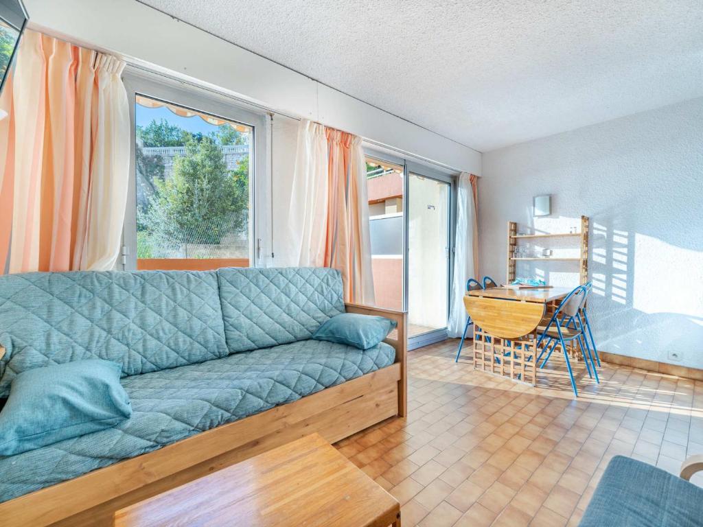 un salon avec un canapé bleu et une table dans l'établissement Appartement 6 pers, Wifi, vue mer splendide - FR-1-827-38, à Roquebrune-Cap-Martin