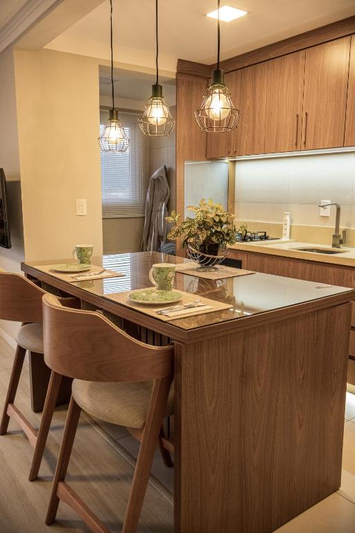 a kitchen with a large island with chairs and lights at apto Casal Canela in Canela