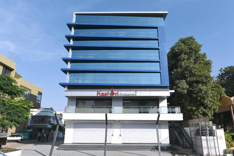 een hoog gebouw met een bord ervoor bij Hotel Sach Regency in Anand