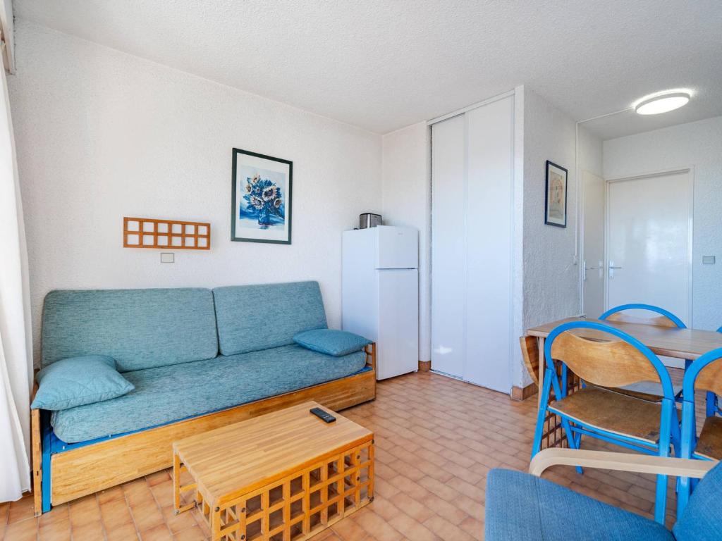 un salon avec un canapé bleu et une table dans l'établissement Studio confortable avec WiFi pour 4 personnes à Roquebrune-Cap-Martin - FR-1-827-75, à Roquebrune-Cap-Martin