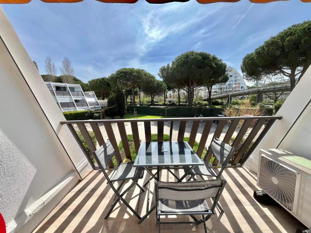 - une table et des chaises sur le balcon d'un appartement dans l'établissement Studio climatisé avec parking près des plages - FR-1-716-85, à La Grande Motte