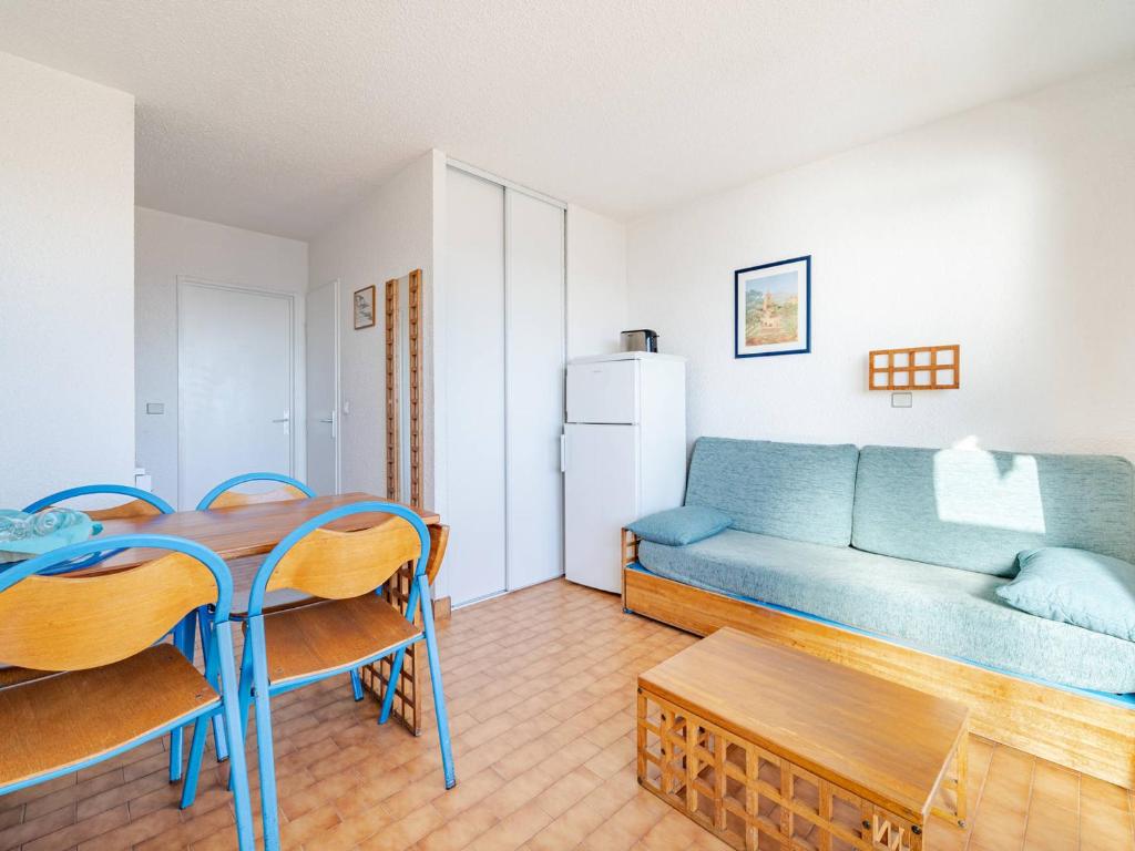 un salon avec un canapé bleu et une table dans l'établissement Studio pour 4 avec Wi-Fi inclus, vue sur mer à Roquebrune-Cap-Martin - FR-1-827-64, à Roquebrune-Cap-Martin